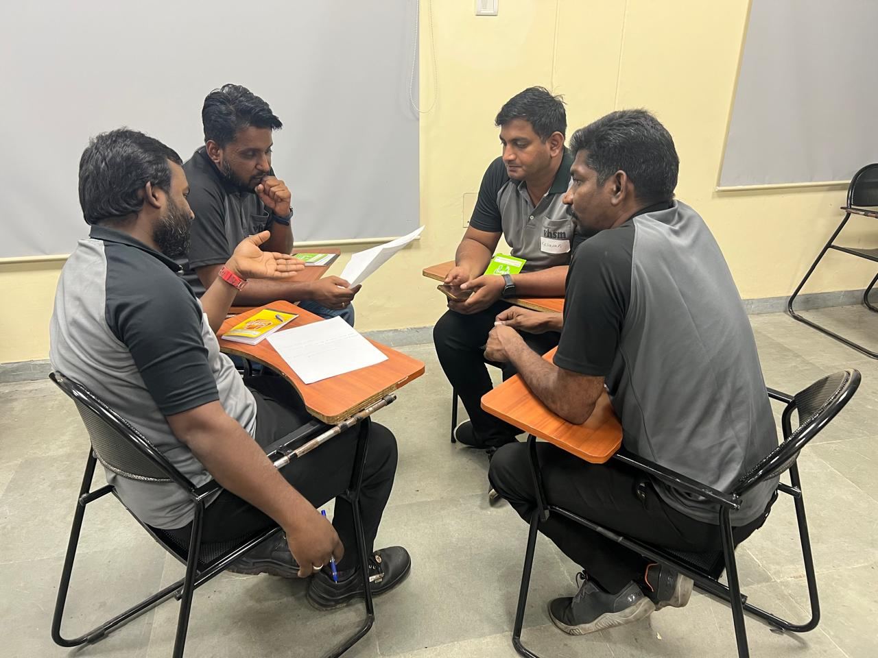 Colleagues seated in a close group reviewing printed material during a discussion
